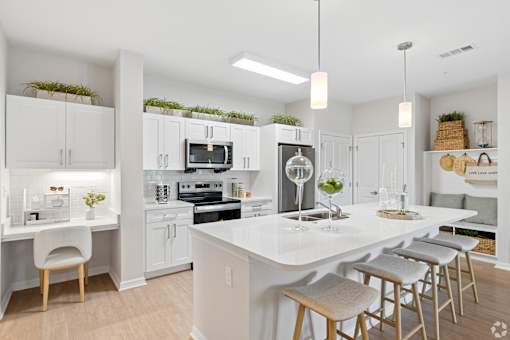 A modern kitchen with white cabinets and a large island.
