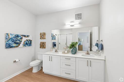 A white bathroom with a white toilet and a white sink.