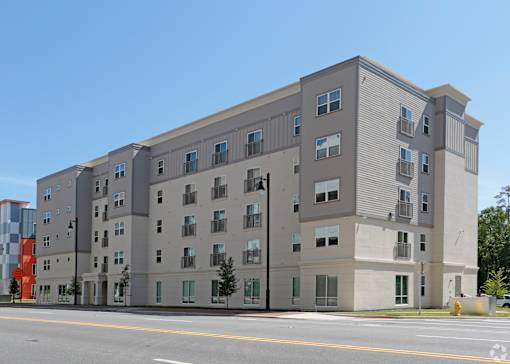 A large grey building with many windows is situated on a street at Arbours at Tumblin Creek ~ Active 55+ Adult Community, Gainesville, Florida
