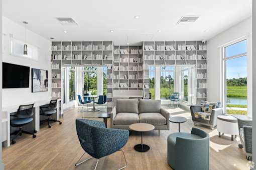 A modern living room with a large window and a bookshelf.