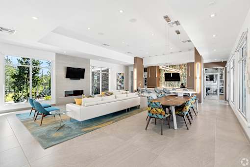 A modern living room with a white sofa and a blue rug.