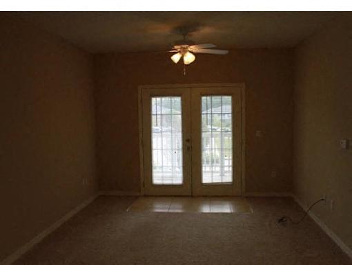 A room with a ceiling fan and a window with glass doors at Arbours at Ensley Apartments, Florida 32514