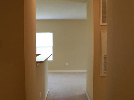 A hallway with a window and a door on the right at Arbours at Ensley Apartments, Pensacola, FL