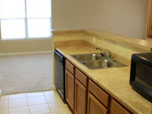 A kitchen with a sink and microwave at Arbours at Ensley Apartments, Pensacola, 32514