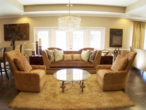 A living room with a brown sofa, two matching chairs and a coffee table at Arbours at Ensley Apartments, Pensacola, Florida