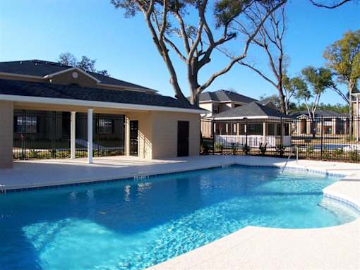 A swimming pool in front of a house at Arbours at Ensley Apartments, Florida