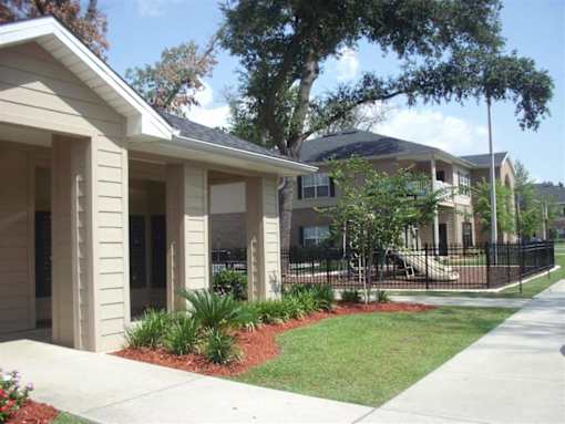 A row of houses with a sidewalk in front at Arbours at Ensley Apartments, Florida 32514