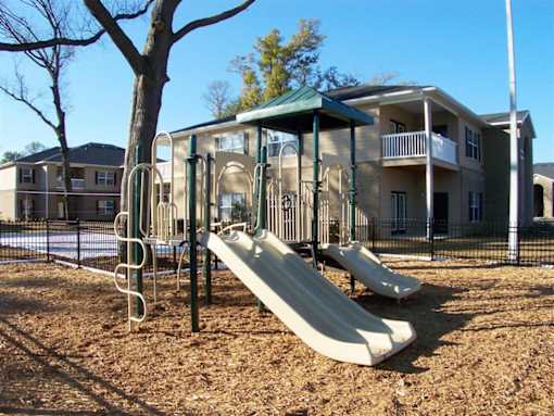 A beige building with a balcony and a staircase at Arbours at Ensley Apartments, Pensacola, 32514