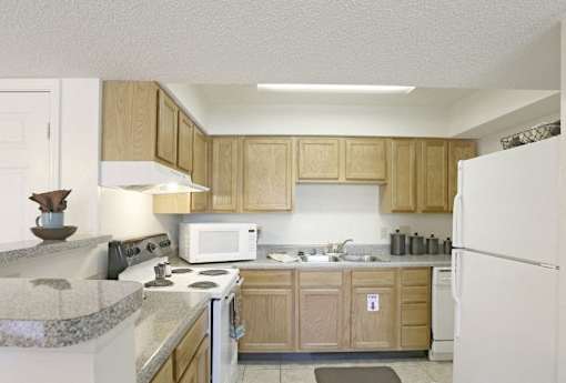 A Kitchen With Wooden Cabinets at Magnolia Court Apartments, Birmingham, AL