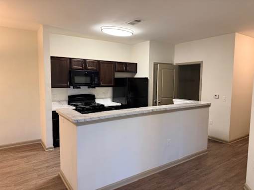 A kitchen with a white counter and black appliances.