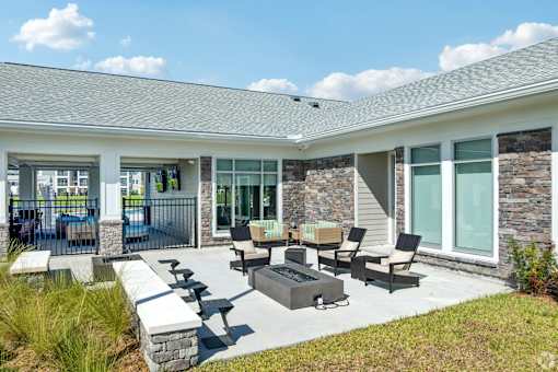 A patio area with a table and chairs outside a house.
