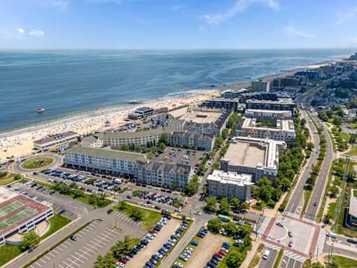 A beachfront cityscape with a parking lot in the foreground.