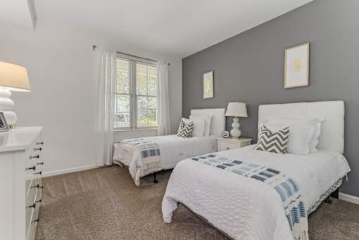 Two bedrooms with white beds and pillows.