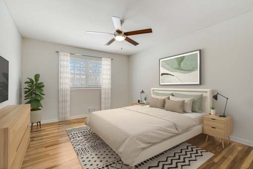 A bedroom with a large bed, a ceiling fan, and a plant. at Chatham Hill, New Jersey, 07928