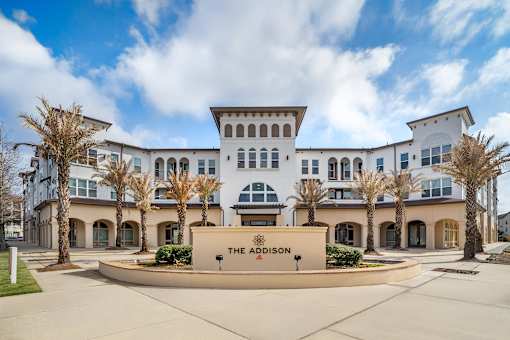 The front of a white building with a sign that says at The Addison,Louisiana