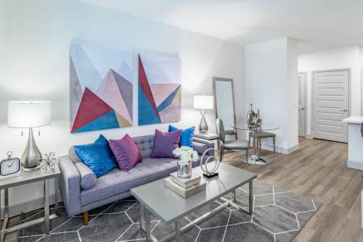 Grey sofa with blue pillows at Alys Crossing Apartments, TX, 77433