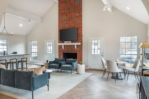 A living room with a grey couch and a fireplace.
