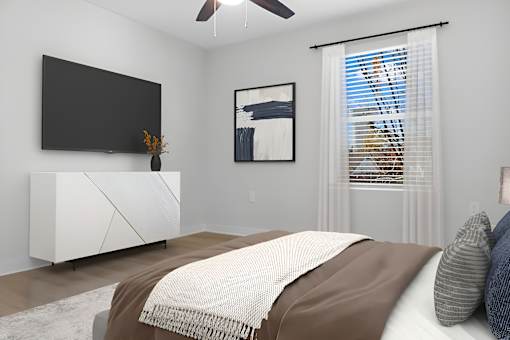 A bedroom with a bed, a television, and a painting on the wall.