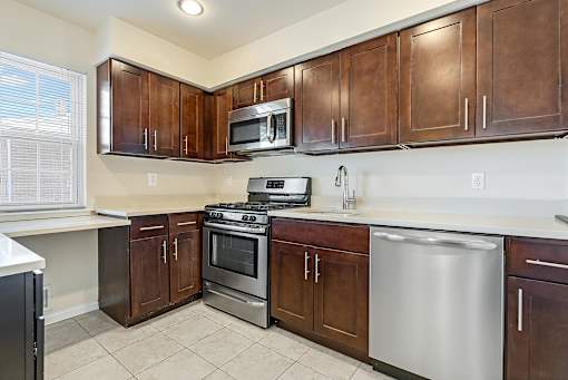 A kitchen with brown cabinets and stainless steel appliances. at Chatham Hill, New Jersey, 07928