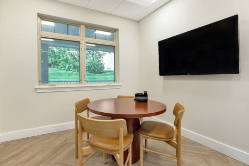 a dining area with a table and a tv on the wall at Copper and Quarry Village, Maryland