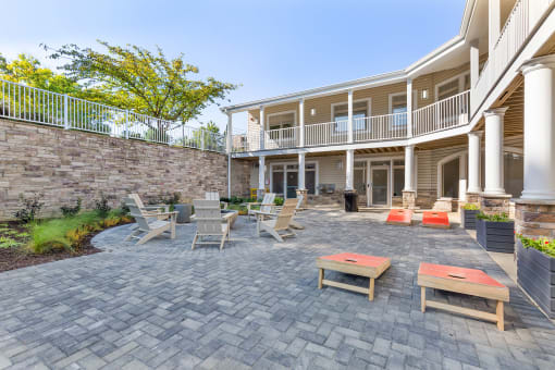a patio with tables and chairs in front of a house at Copper and Quarry Village, Pikesville, MD