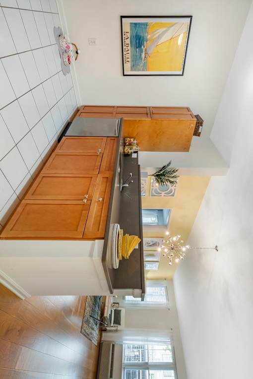 a kitchen with wooden cabinets and a counter top at Pier Village Apartments, Long Branch, NJ