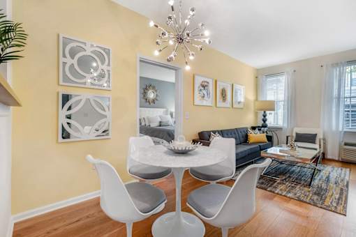 a living room with a couch and a table with chairs at Pier Village Apartments, Long Branch, New Jersey