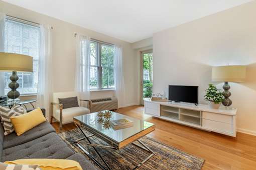 a living room with a couch and a coffee table and a television at Pier Village Apartments, Long Branch