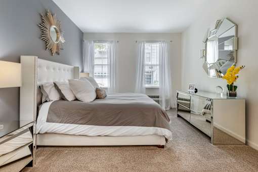 a bedroom with a large bed and a mirror on the wall at Pier Village Apartments, New Jersey