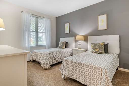 a bedroom with two beds and a window at Pier Village Apartments, Long Branch, New Jersey