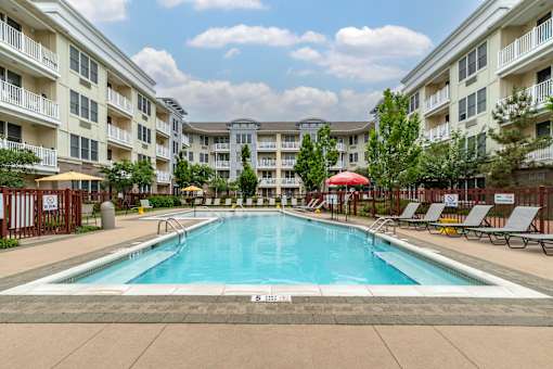 a swimming pool with an apartment building in the background at Pier Village Apartments, New Jersey, 07740