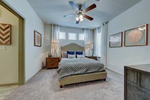 Bedroom with bed, lamps, ceiling fan and light Bedroom with bed, lamps, ceiling fan and light at Estraya Westover Hills, San Antonio, Texas