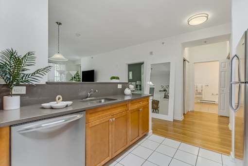 A modern kitchen with wooden cabinets and a white fridge.
