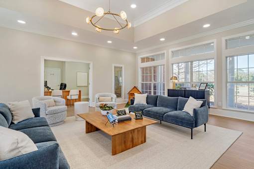 A living room with a blue couch and a wooden coffee table. at Greenbrier Estates, Slidell, 70460