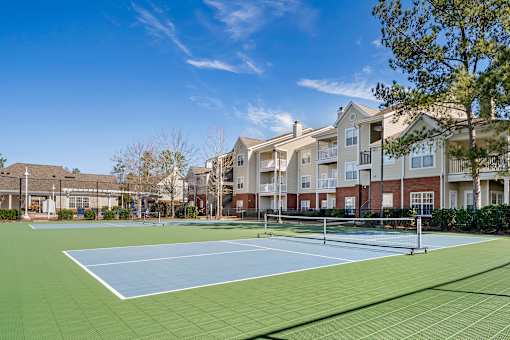 A tennis court is surrounded by apartment buildings. at Greenbrier Estates, Slidell, 70460