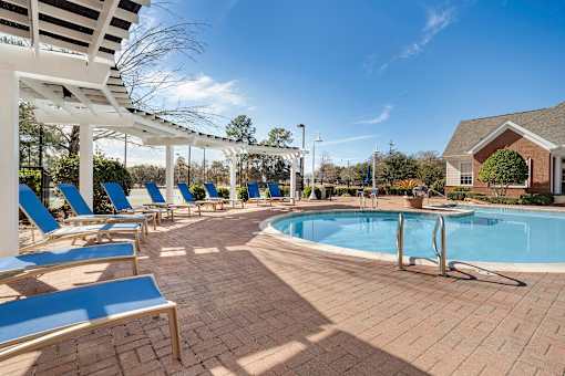 A pool surrounded by sun loungers and a white pergola. at Greenbrier Estates, Slidell, 70460