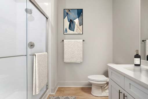 A bathroom with a toilet, sink, and shower. at Midtown Row, Alabama