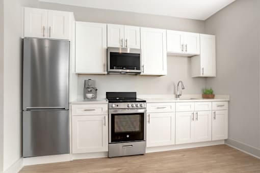 A kitchen with white cabinets and a stainless steel refrigerator. at Midtown Row, Montgomery, 36106