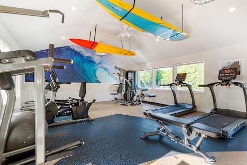 a gym with cardio equipment and a surfboard on the ceiling at Quail Ridge, Plainsboro Township