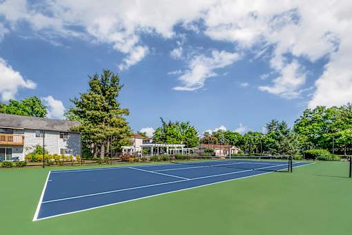 a tennis court with trees and a house in the background at Quail Ridge, Plainsboro Township, NJ