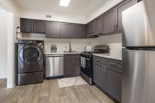 a kitchen with gray cabinets and stainless steel appliances at Copper and Quarry Village, Maryland, 21209