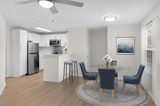 A modern kitchen with a dining table set for four. at Reflection Pointe, Flowood, MS