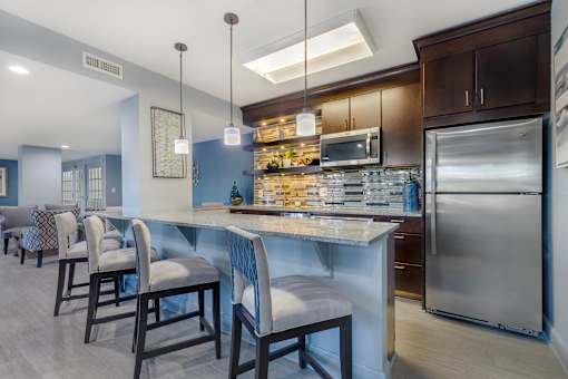 A kitchen with a table and chairs.