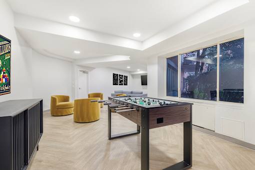 A room with a foosball table and a framed picture on the wall.