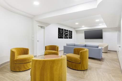 A room with yellow chairs and a grey couch.