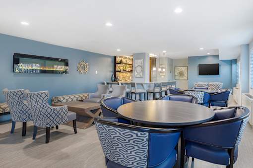A modern dining room with a large table surrounded by chairs.