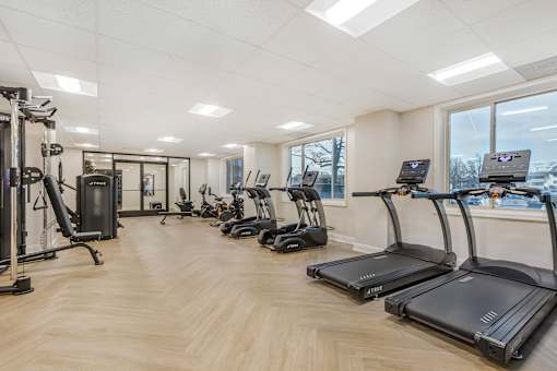 A gym with treadmills, weights, and exercise equipment.