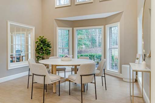 A dining room with a table and chairs.