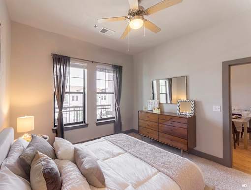 a bedroom with a large bed and a ceiling fan at The Addison, Baton Rouge