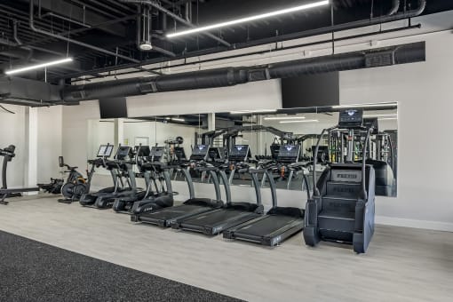 a row of cardio machines in a gym